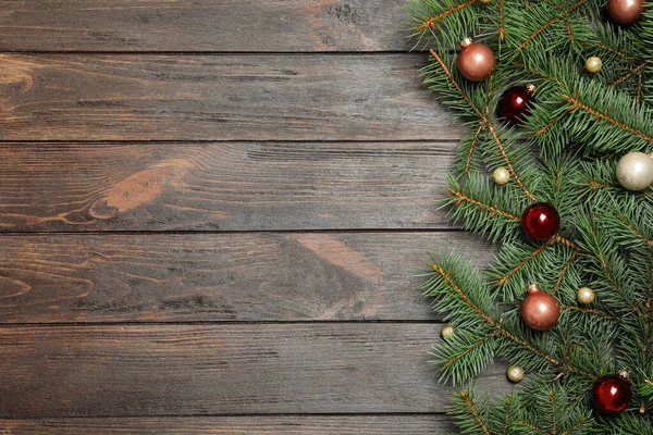 Ramos de abeto com decoração de Natal em fundo de madeira, flat lay. Espaço para texto — Fotografia de Stock