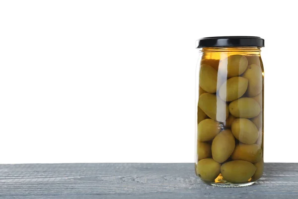 Tarro de aceitunas en vinagre sobre mesa de madera azul sobre fondo blanco. Espacio para texto — Foto de Stock