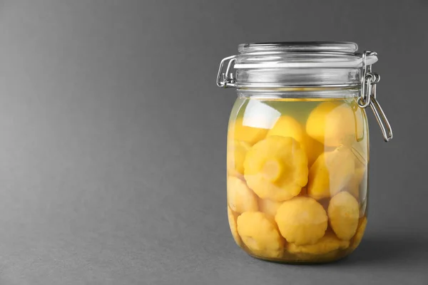 Jar of pickled custard squashes on grey background. Space for text — Stock Photo, Image