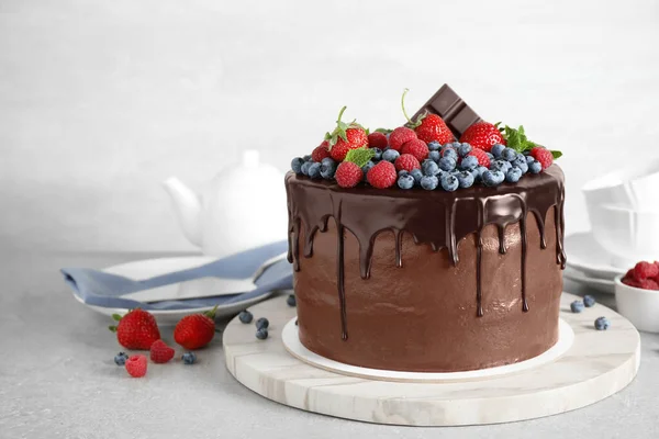 Frisch zubereiteter leckerer Schokoladenkuchen mit Beeren auf weißem Tisch — Stockfoto