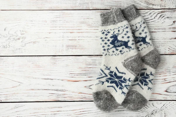 Warm knitted socks on white wooden background, flat lay. Space for text — Stock Photo, Image