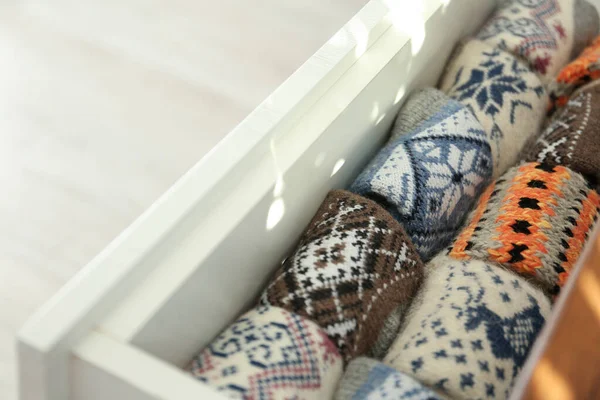 Diferentes meias de malha quente dobrado na gaveta dentro de casa — Fotografia de Stock
