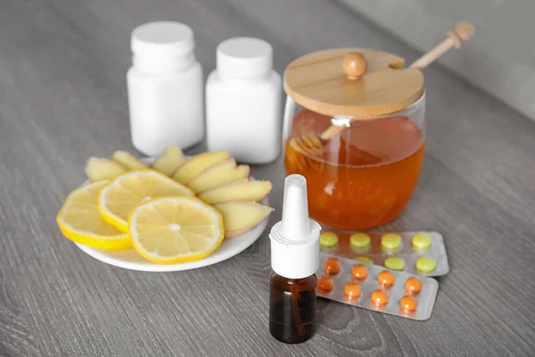 Nasal spray and different cold remedies on wooden table