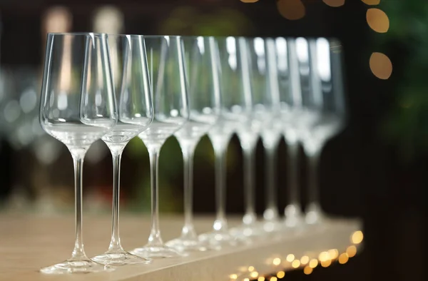 Set lege wijnglazen op grijze tafel tegen wazige achtergrond — Stockfoto