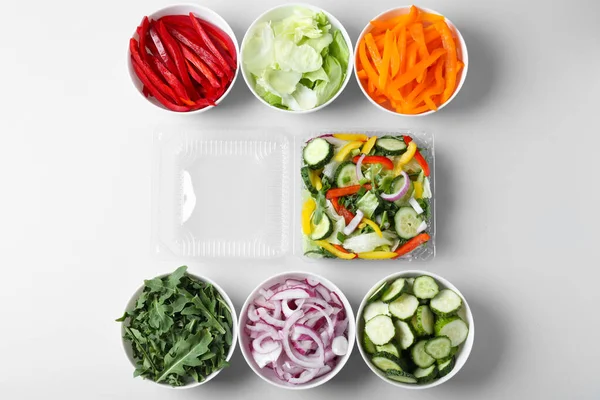 Свежий салат и ингредиенты на белом фоне, вид сверху — стоковое фото
