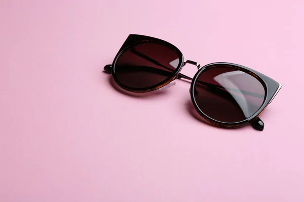 Snygga solglasögon på rosa bakgrund, utrymme för text. Fashionabla tillbehör — Stockfoto