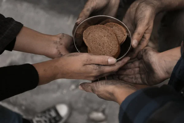 Poor homeless people with pieces of bread outdoors, closeup — Stock Photo, Image