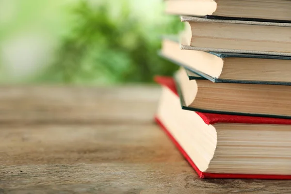 Stapel hardcover boeken op houten tafel tegen wazige achtergrond, close-up. Ruimte voor tekst — Stockfoto