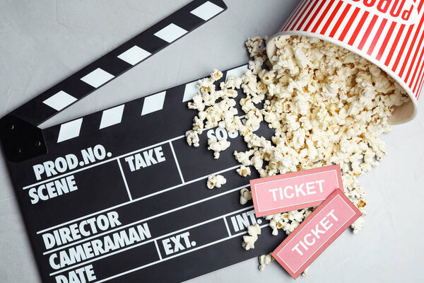 Flat lay composition with popcorn and cinema tickets on grey background