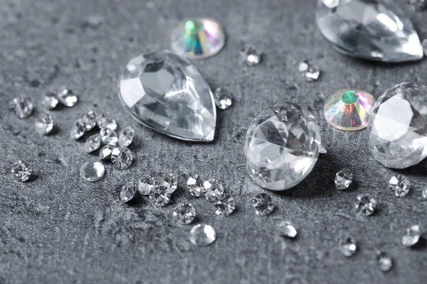 Krásné drahokamy pro šperky na šedém pozadí, detailní záběr — Stock fotografie