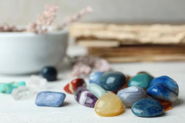 Pilha de pedras preciosas diferentes na mesa de madeira branca. Espaço para texto — Fotografia de Stock