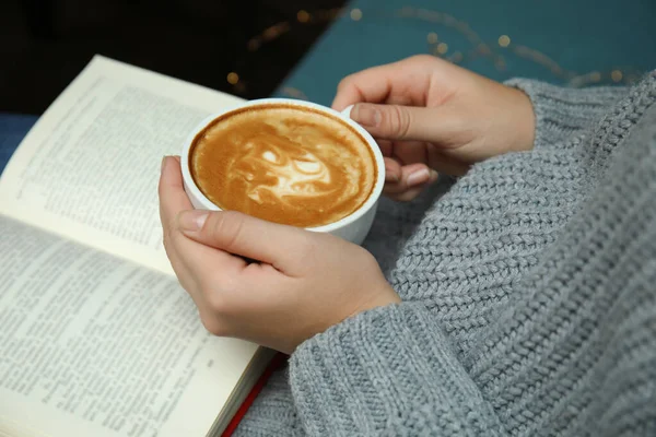 Mulher com xícara de café livro de leitura em casa, close-up — Fotografia de Stock