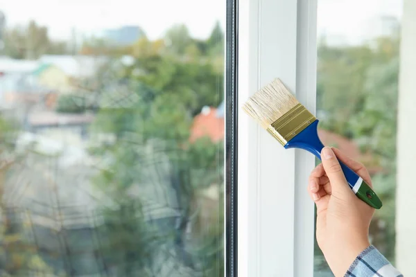 Mulher pintura moldura da janela em casa, close-up — Fotografia de Stock