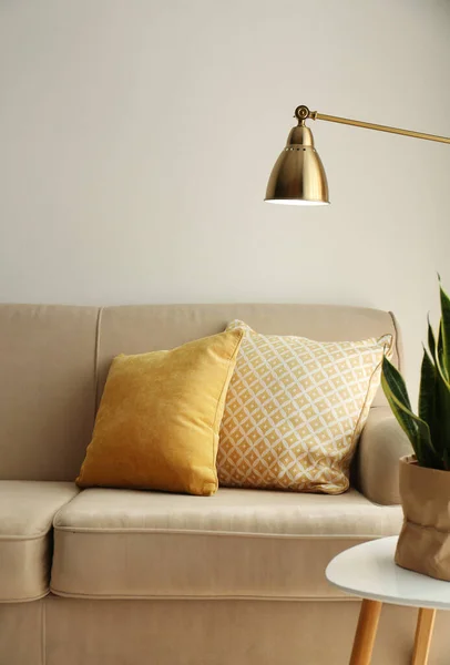 Cómodo sofá con almohadas suaves en el interior del salón —  Fotos de Stock