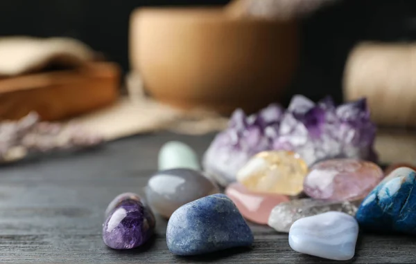 Muitas pedras preciosas diferentes na mesa de madeira preta — Fotografia de Stock