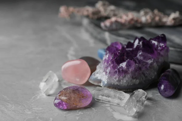 Много различных драгоценных камней на сером мраморном столе — стоковое фото