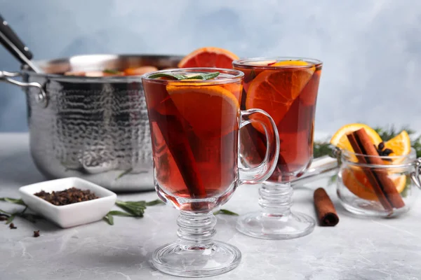 Tasty mulled wine with spices on grey marble table — Stock Photo, Image