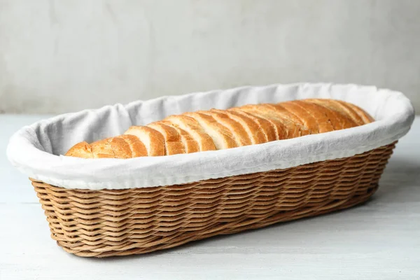 白色木制桌子上的篮子里有几片面包 — 图库照片
