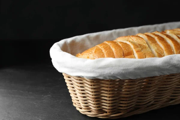 Fette di pane in cesto su tavolo nero — Foto Stock