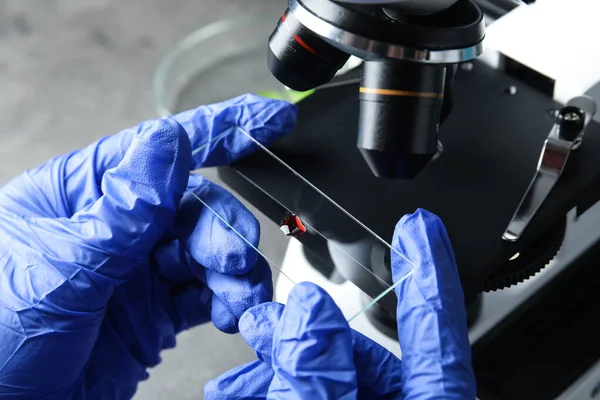 Assistente médico usando microscópio na mesa, close-up — Fotografia de Stock