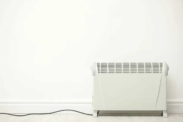 Moderne elektrische kachel in de buurt van witte muur binnen. Ruimte voor tekst — Stockfoto