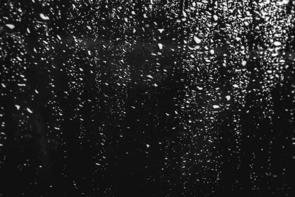 Cristal con gotas de lluvia sobre fondo negro — Foto de Stock