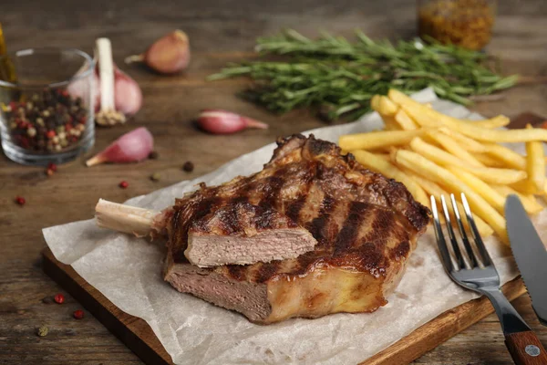 Lekkere gegrilde biefstuk en frietjes op houten tafel — Stockfoto