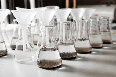 Masada toprak özü ve hunileri olan laboratuvar camları.