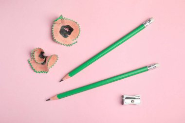 Kalemler, kalemler ve pembe arka planda talaşlar, üst manzara.