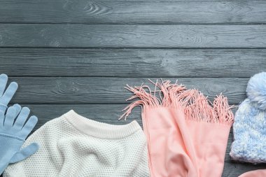 Düz kompozisyon ve koyu ahşap arka planda kalın giysiler. Metin için boşluk