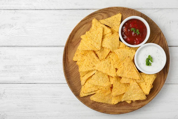 Plate with tasty Mexican nachos chips and sauces on white wooden table, top view. Space for text — Stock Photo, Image