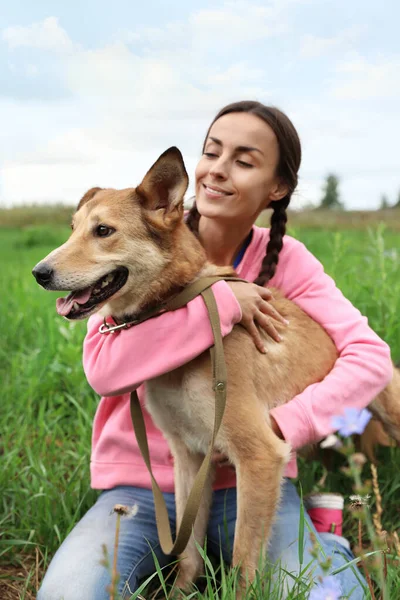 屋外の動物保護施設でホームレスの犬と女性ボランティア — ストック写真