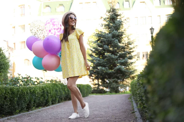 Joven alegre con globos de color en el parque —  Fotos de Stock