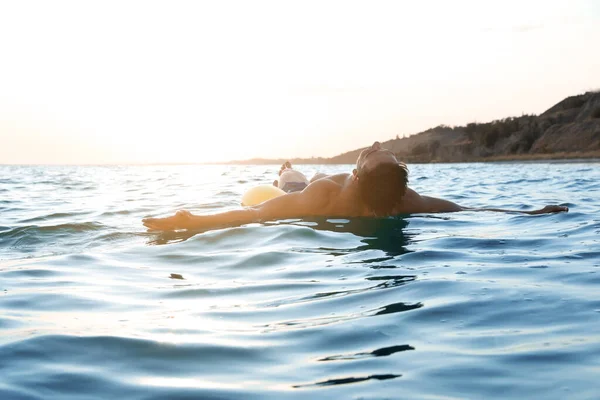 Jovem com anel inflável no mar — Fotografia de Stock