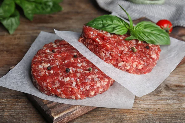 Costolette di carne crude per hamburger su tavolo di legno, primo piano — Foto Stock