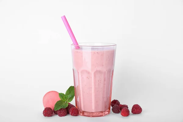 Sabroso batido de leche en vaso, frambuesas y macaron sobre fondo blanco —  Fotos de Stock