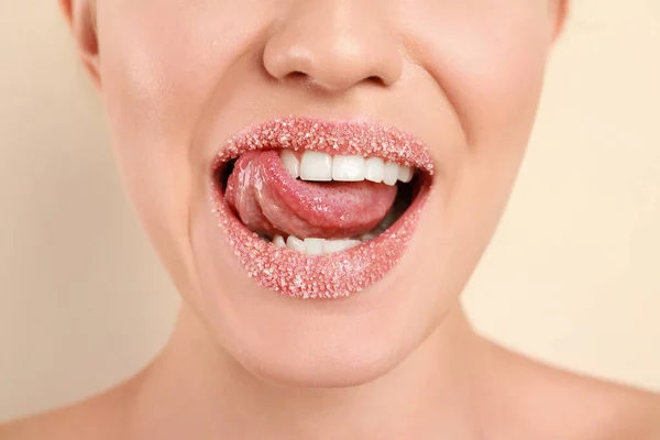Jovem com lábios de açúcar no fundo bege, close-up — Fotografia de Stock