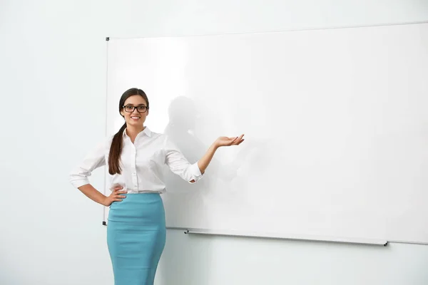 Žena učitel poblíž tabule v moderní učebně — Stock fotografie