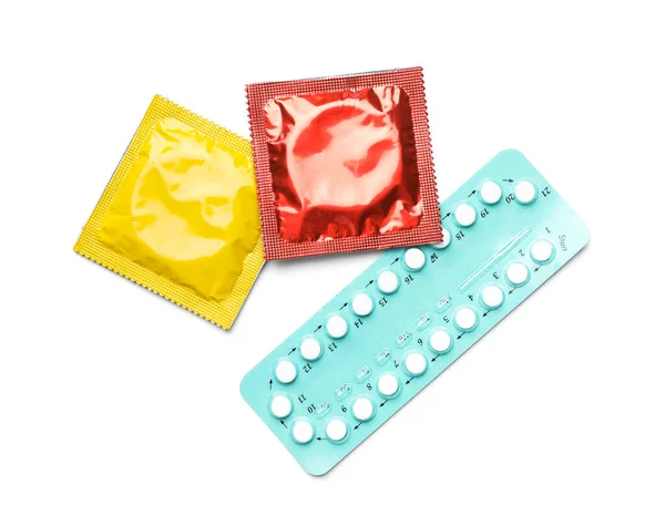 Condoms and birth control pills on white background, top view. Safe sex concept — ストック写真