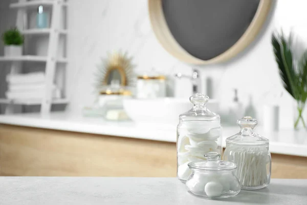 Bolas de algodón, hisopos y almohadillas en la mesa gris claro en el baño — Foto de Stock