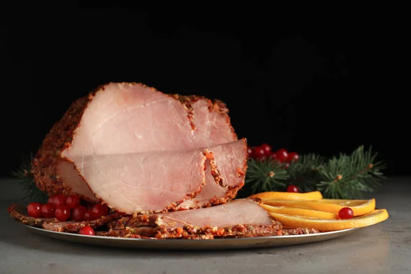 Pyszna szynka serwowana na świąteczny obiad na szarym stole na czarnym tle — Zdjęcie stockowe