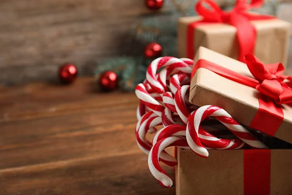 Candy canes in gift box on wooden table, space for text. Traditional Christmas treat — Stock Photo, Image