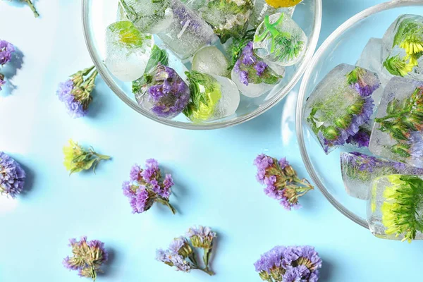 Is kuber med blommor och glas skålar på blå bakgrund, platt låg — Stockfoto