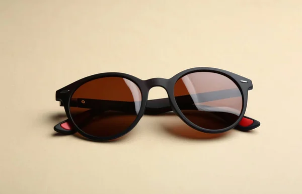 Lunettes de soleil élégantes sur fond beige. Accessoire tendance — Photo