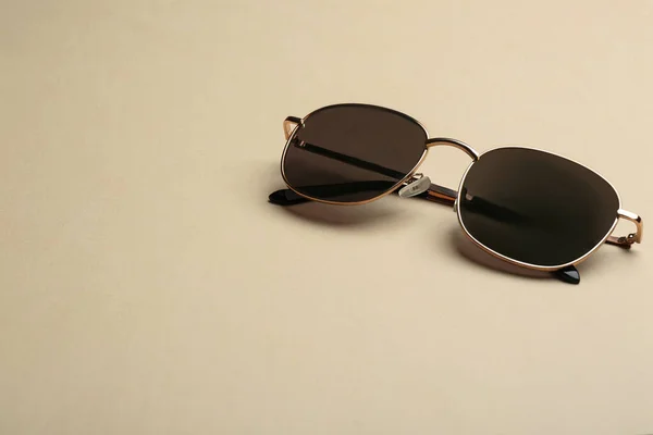 Elegantes gafas de sol sobre fondo beige, espacio para texto. Accesorio de moda — Foto de Stock