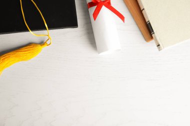 Mezuniyet şapkası ve öğrenci diploması beyaz ahşap masa, düz yatış. Metin için boşluk