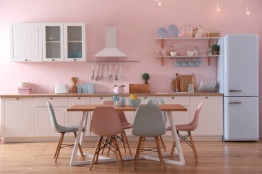 Yemek masası ve sandalyeleri olan şık bir mutfak.