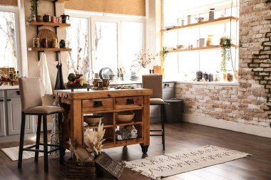 Ahşap masa ve sandalyelerle süslü bir mutfak.