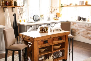 Ahşap masa ve sandalyelerle süslü bir mutfak.