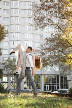 Güzel, genç bir çift dışarıda dans figürleri yapıyor.